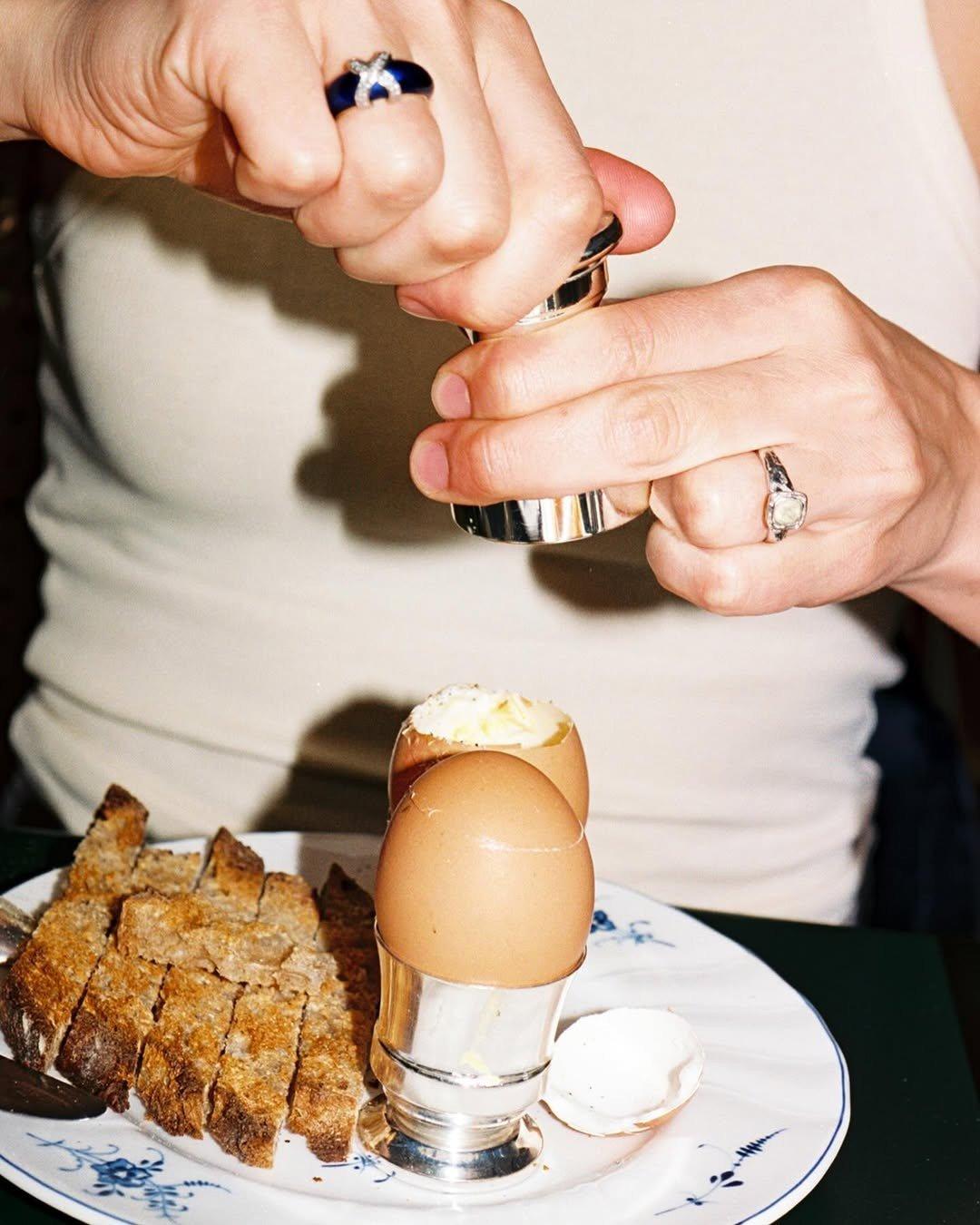 Du sel déposé sur un oeuf à la coque dans un coquetier, avec des mouillettes