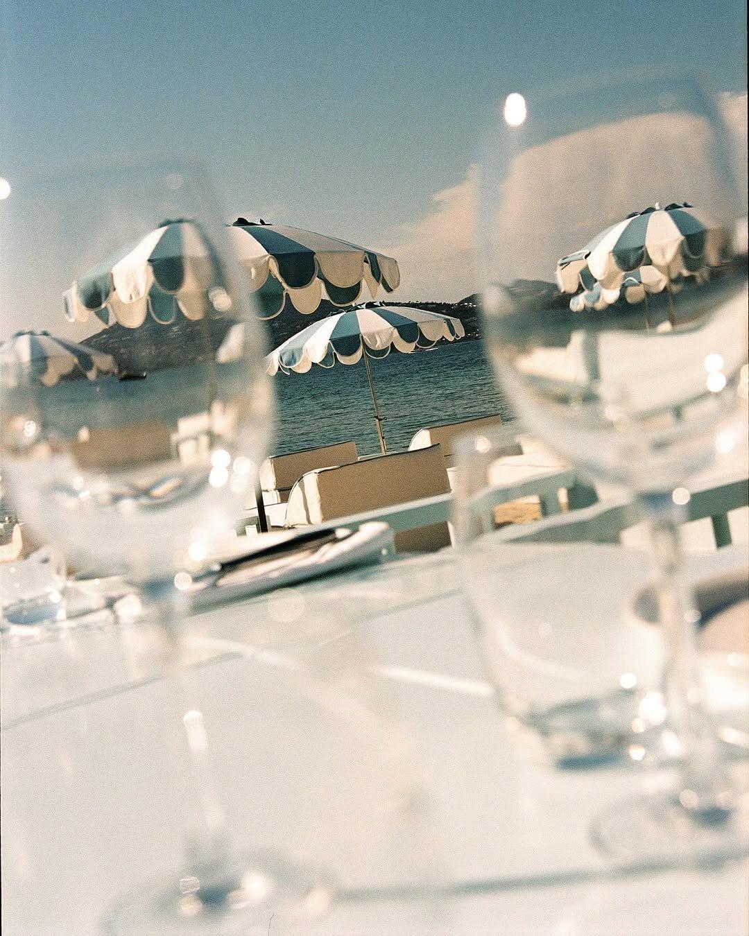 Parasols rayés et verres sur la terrasse, au bord de l'eau